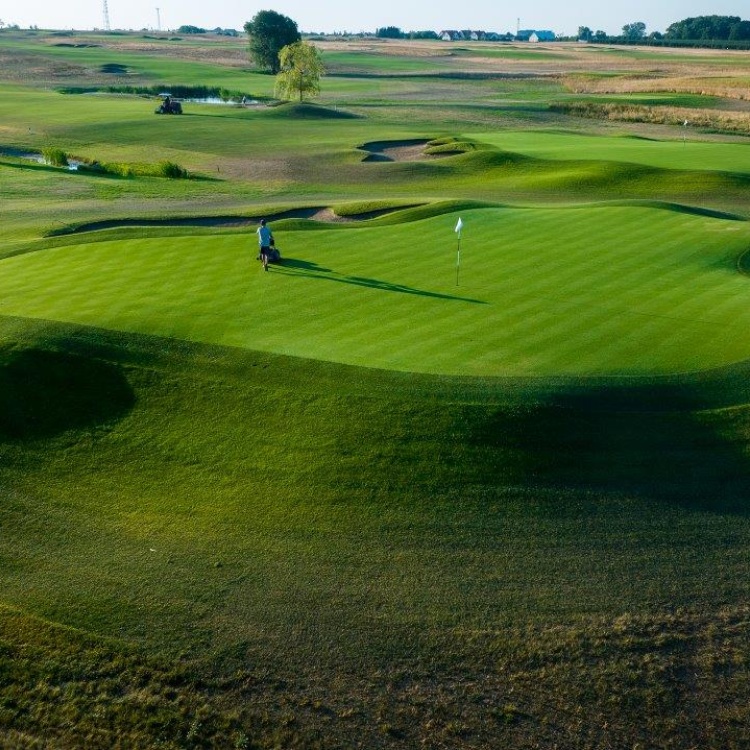 Zbliżenie z lotu ptaka na green i staw w tle na polu golfowym Black Water Links